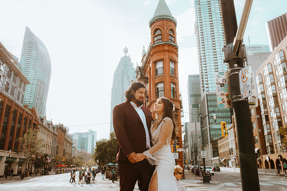 The Burroughes Toronto Wedding Couple stand in front of the Gooderham Building in Toronto