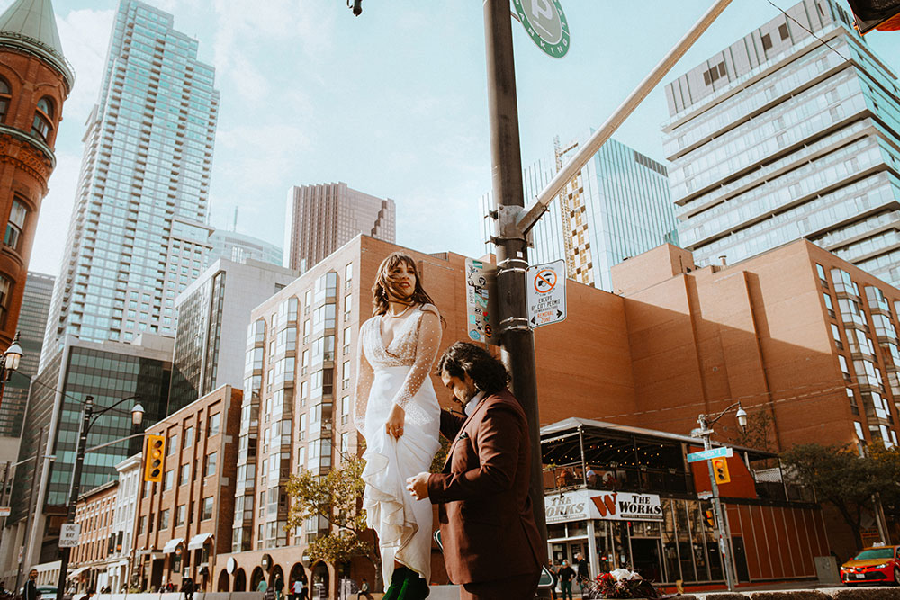 The Burroughes Toronto Wedding Couple stand in front of the Gooderham Building in Toronto