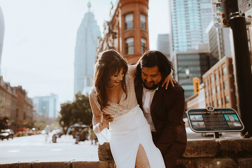 The Burroughes Toronto Wedding Couple stand in front of the Gooderham Building in Toronto