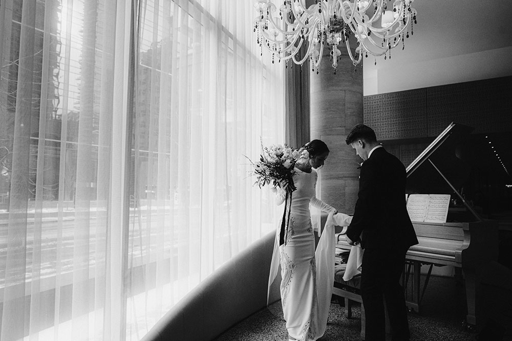 Shangri-La Hotel Toronto Wedding groom & bride sit by piano in hotel lobby