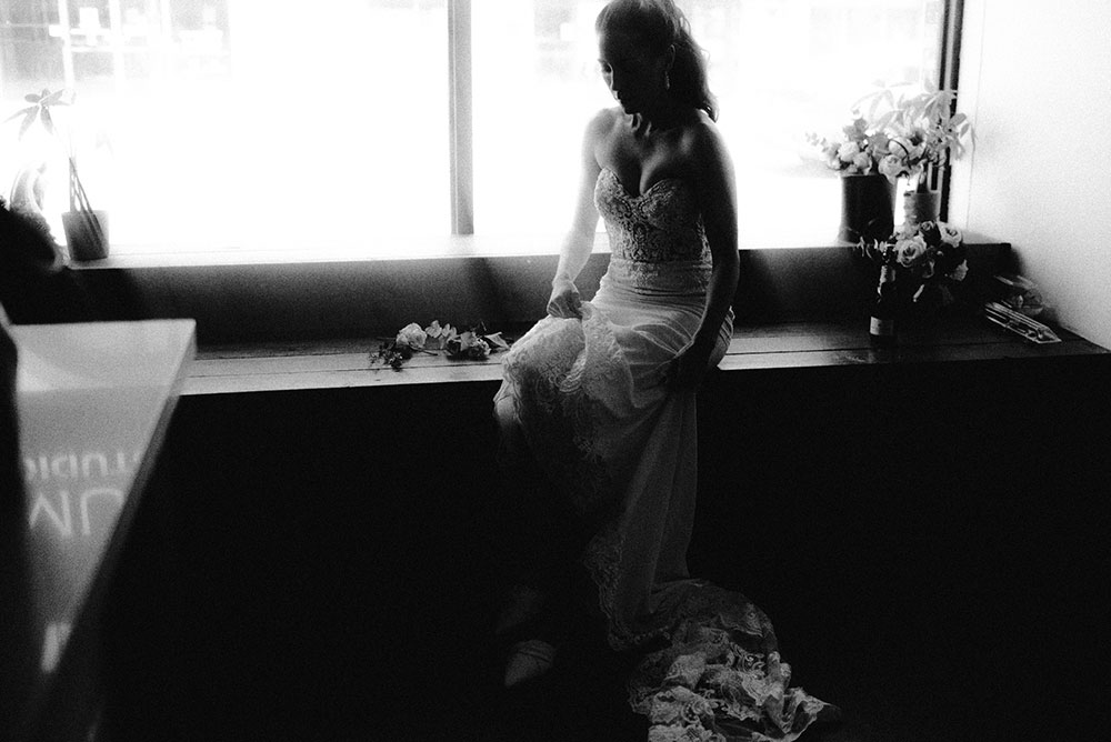 Bride sits in window light before the ceremony