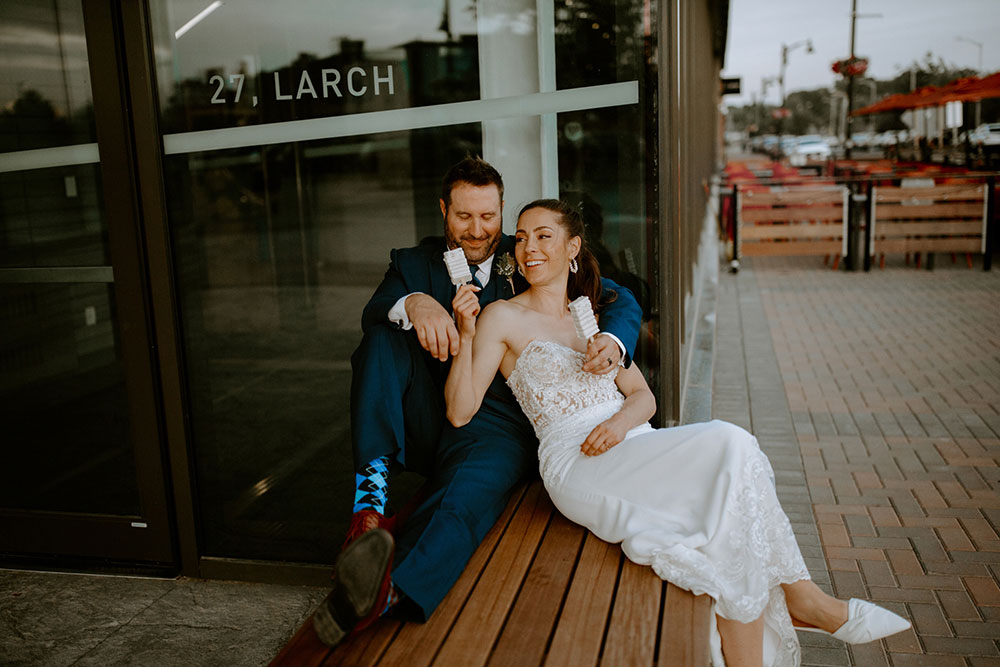 newlyweds enjoy deserts by northern sugar mama while sitting outside Place des artes in Sudbury