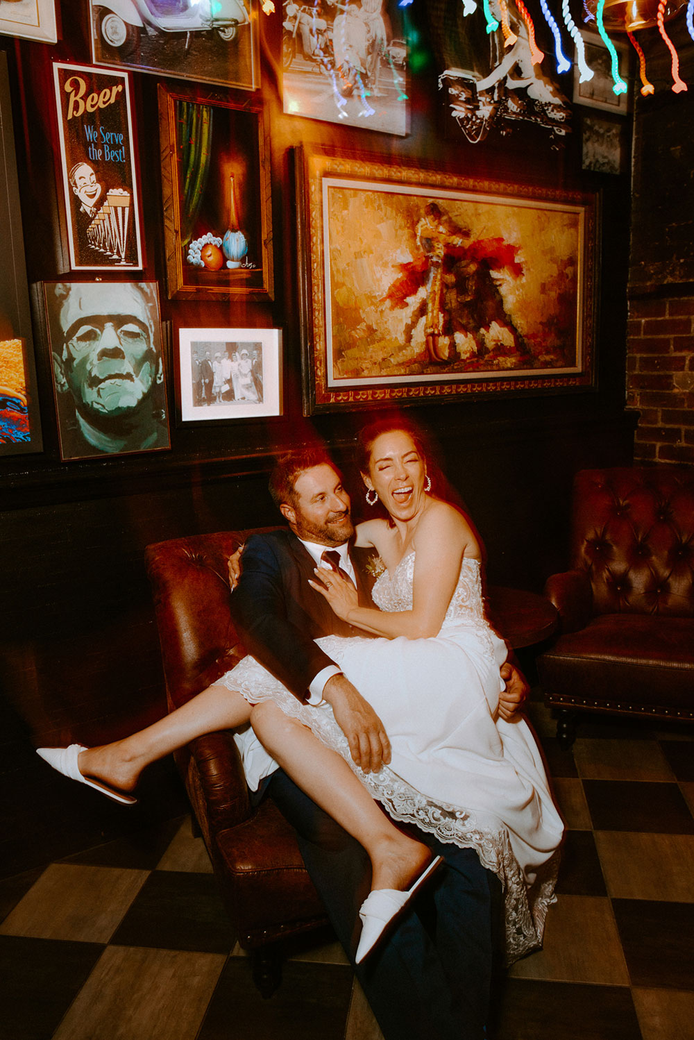 Newlyweds pose in front of wall of art at respect is burning kitchen