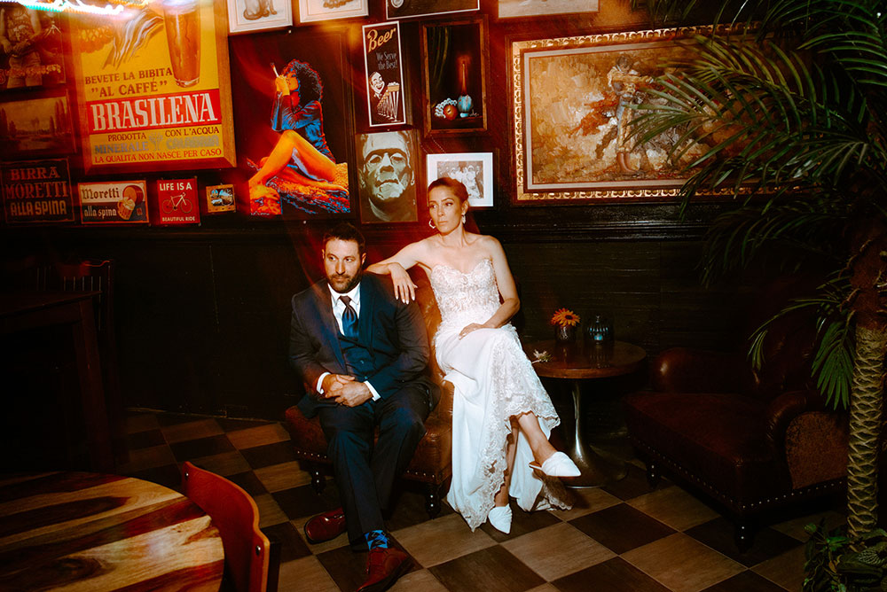 Newlyweds pose in front of wall of art at respect is burning kitchen