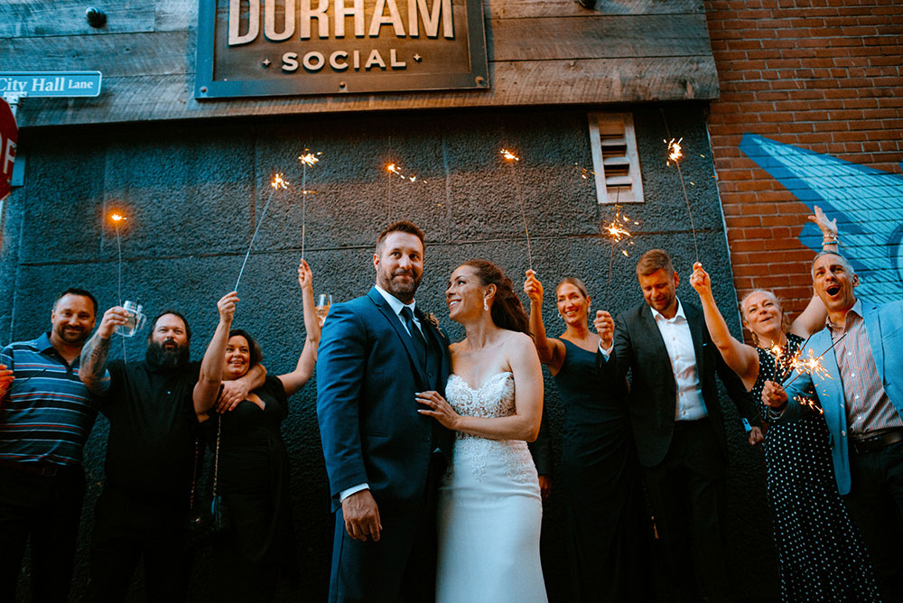 wedding guests with sparklers in the alley way beside respect is burning kitchen