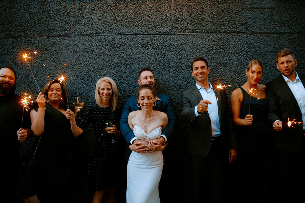 wedding guests with sparklers in the alley way beside respect is burning kitchen