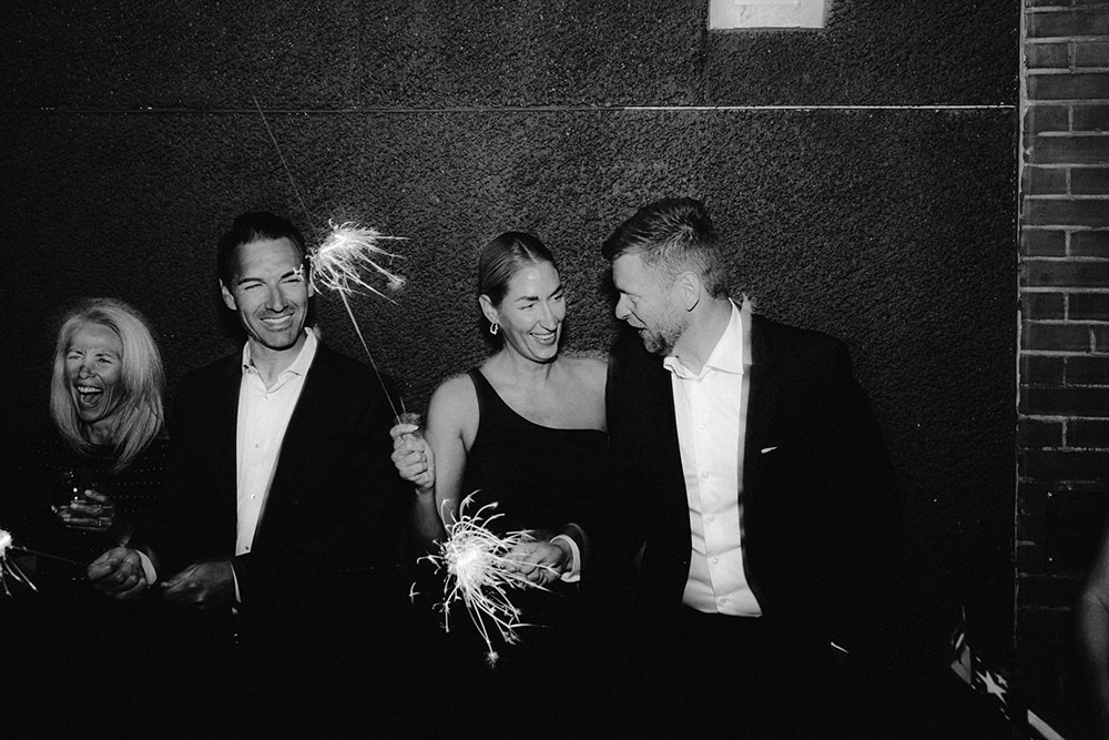 wedding guests with sparklers in the alley way beside respect is burning kitchen