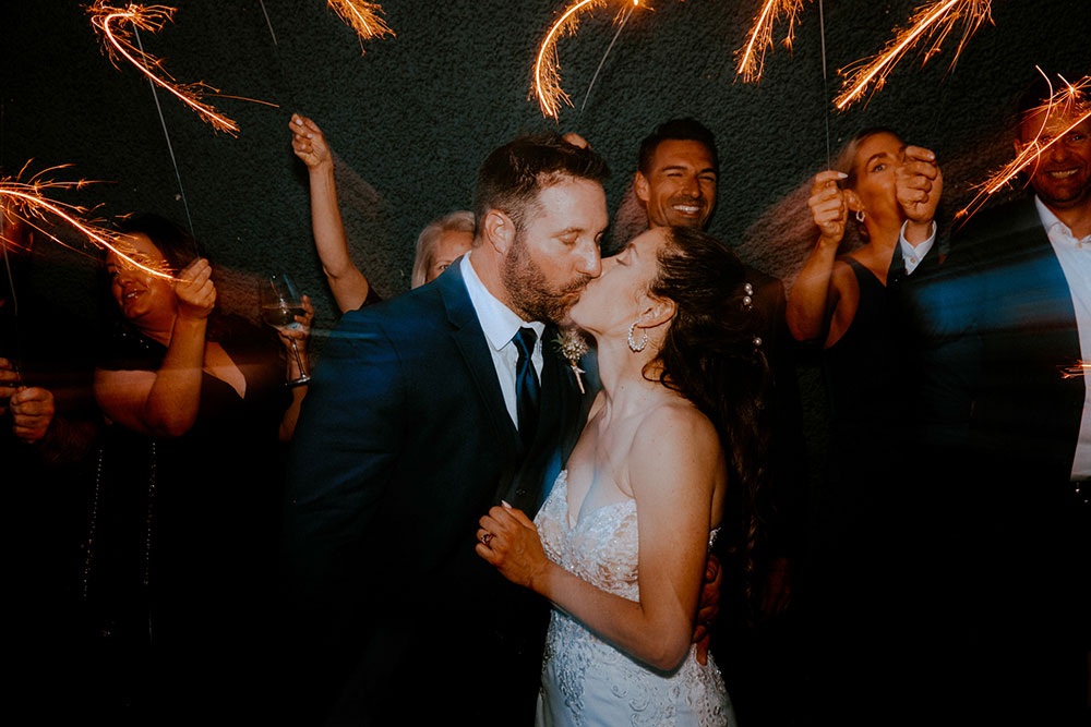 wedding guests with sparklers in the alley way beside respect is burning kitchen