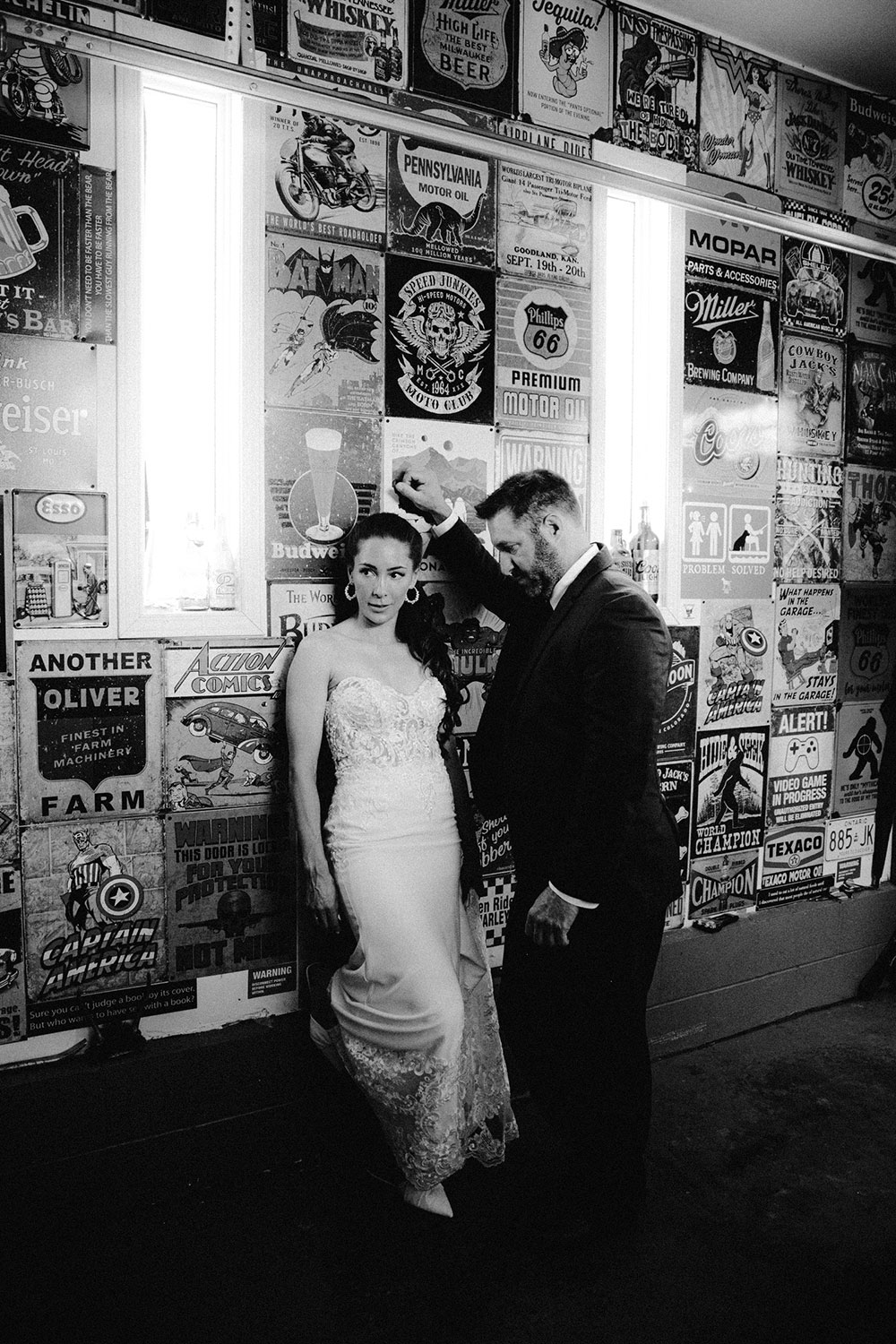 newlyweds pose in garage full of vintage signs