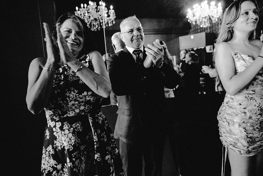 woman claps in joy during a wedding ceremony at the cedar nest in Sudbury