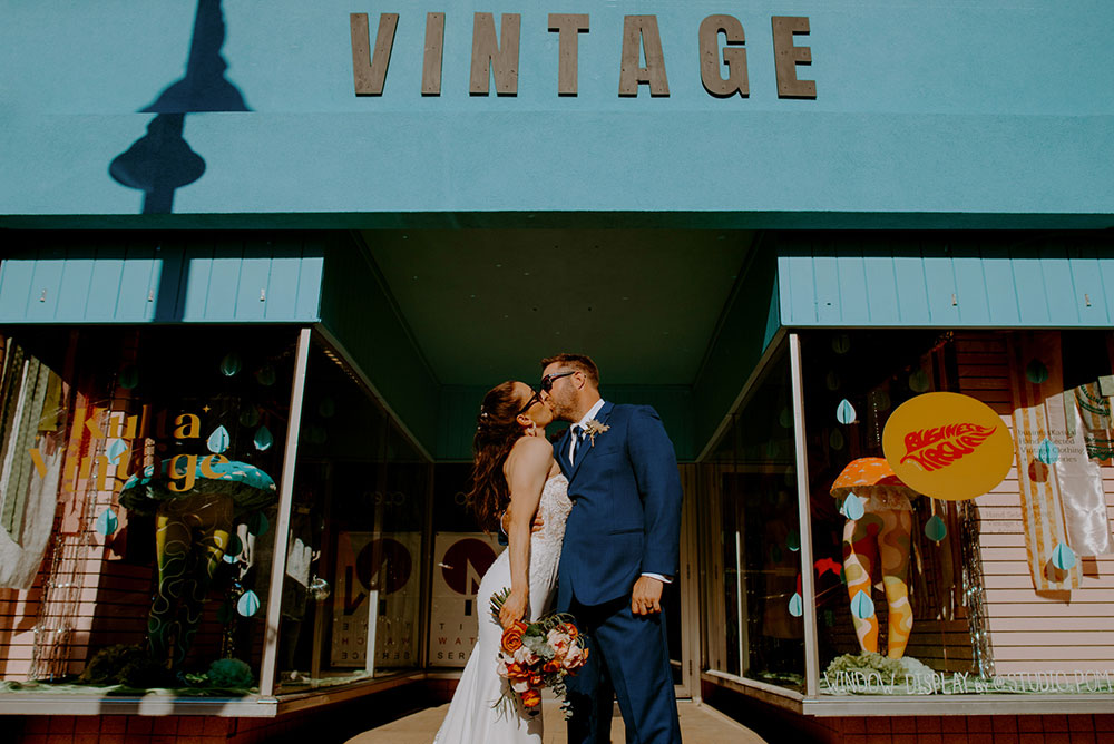 couple kiss with sunglasses in front of Kulta Vintage shop in Sudbury