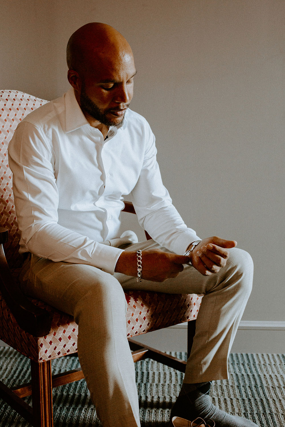 groom fixes his watch as her gets ready at this Bayview Golf Wedding