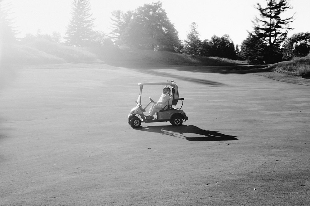 bride and groom drive away on golf cart at this Bayview Golf Wedding