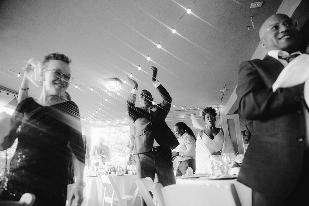 guests stand and cheer for the newlyweds at this Bayview Golf Wedding