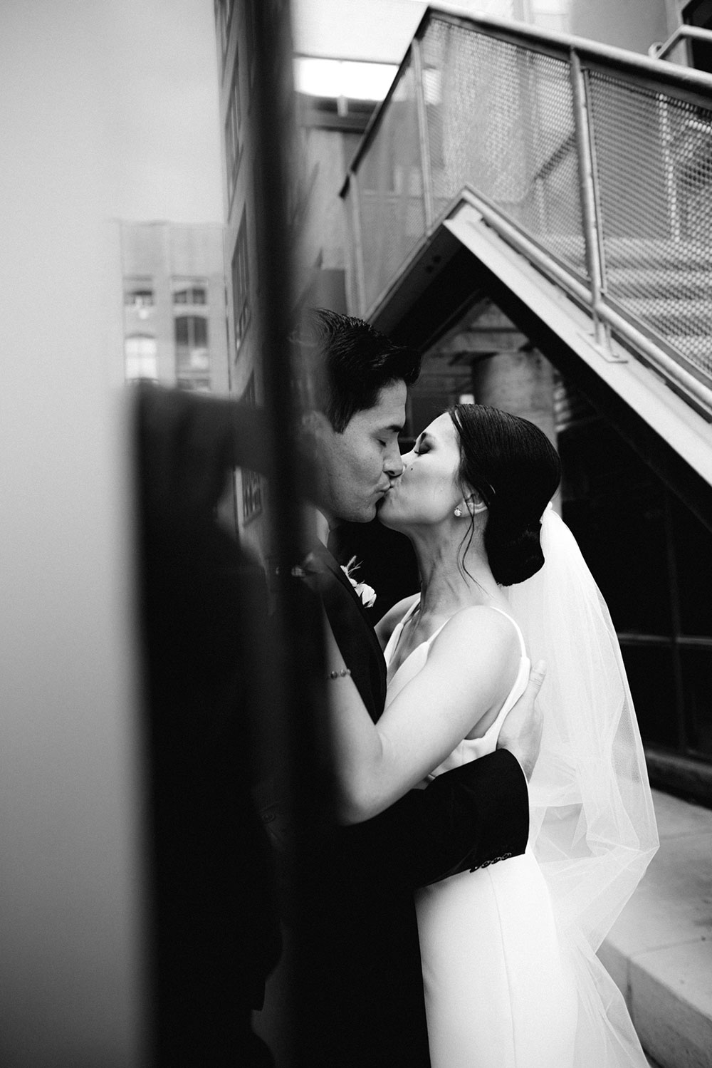 mildred's temple kitchen wedding photography of the wedding couple candidly kissing around liberty village