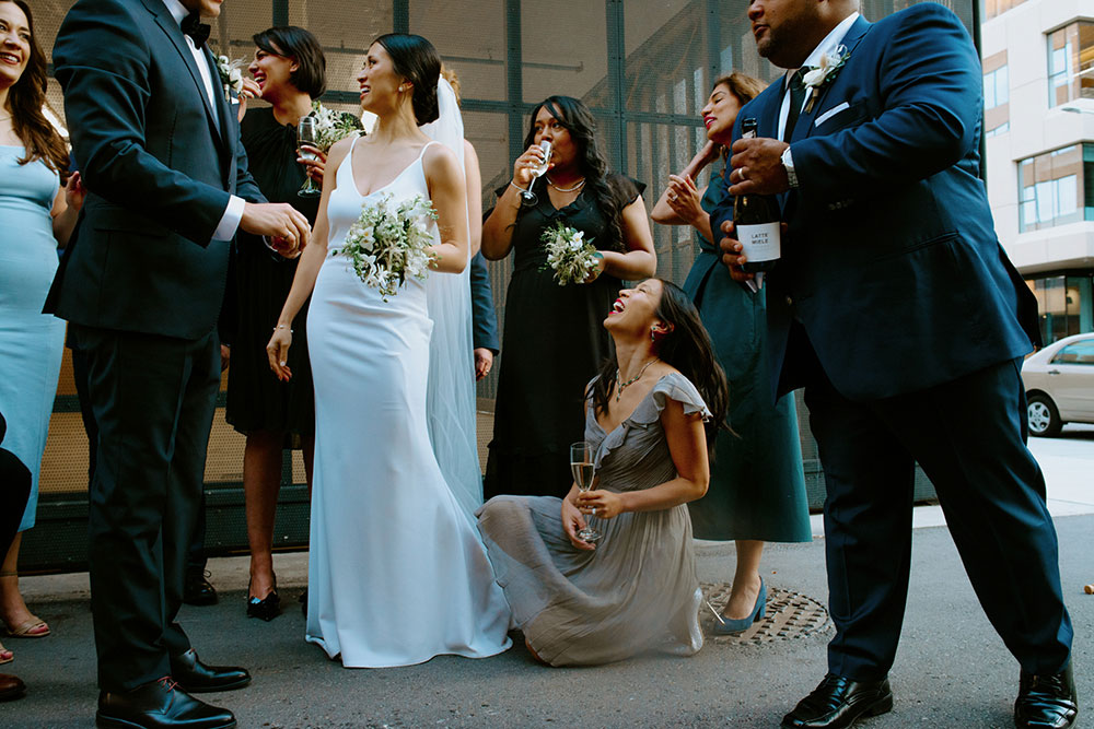 mildred's temple kitchen wedding photography of the wedding couple sharing a champagne pop with their wedding party 