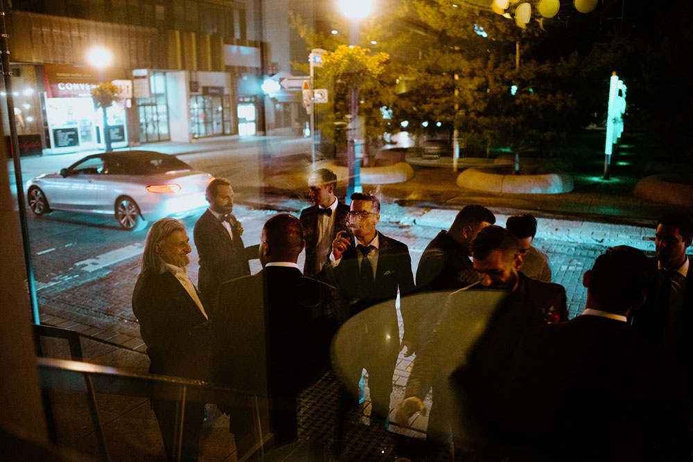 Sassafraz Yorkville Wedding Photography of the wedding party sharing cigars outside in the night air