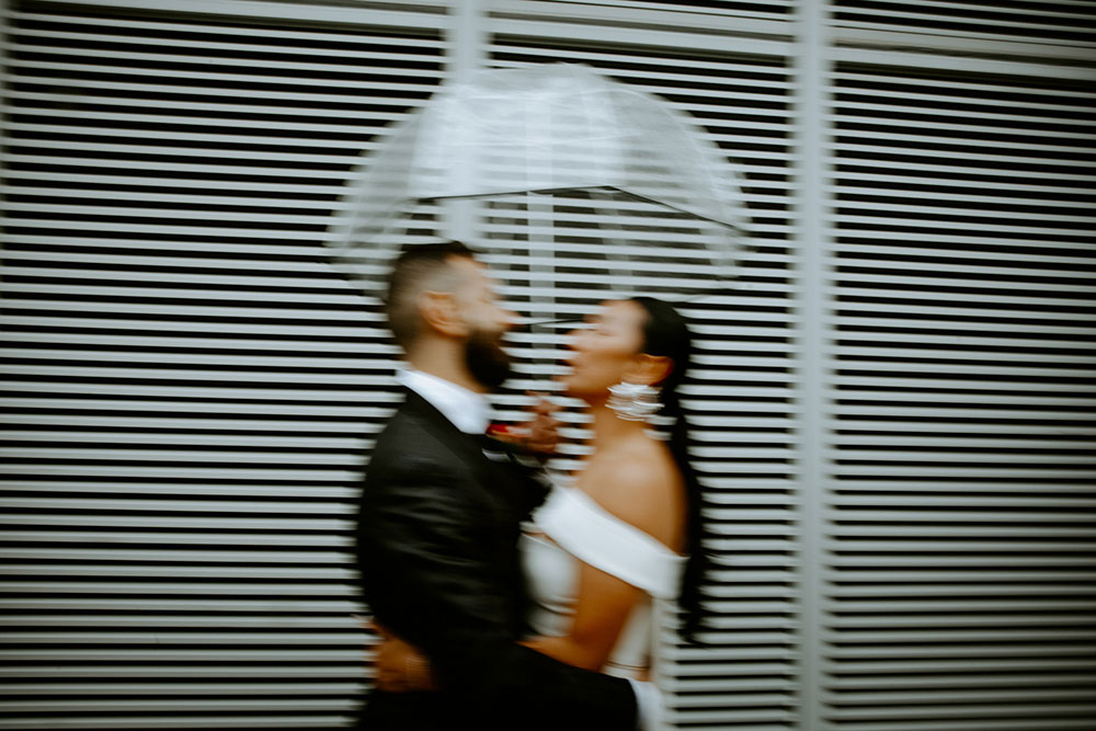 Sassafraz Yorkville Wedding Photography of the bride & groom sharing an umbrella around yorkville