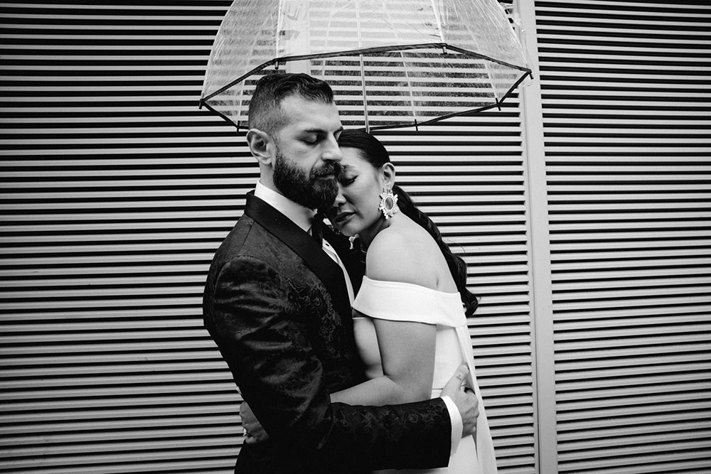 Sassafraz Yorkville Wedding Photography of the bride & groom sharing an umbrella around yorkville