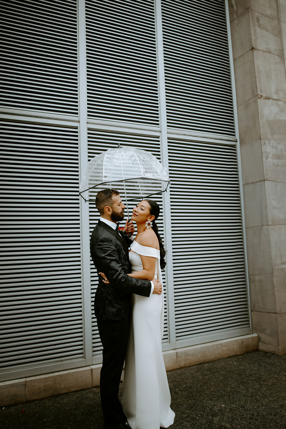 Sassafraz Yorkville Wedding Photography of the bride & groom sharing an umbrella around yorkville