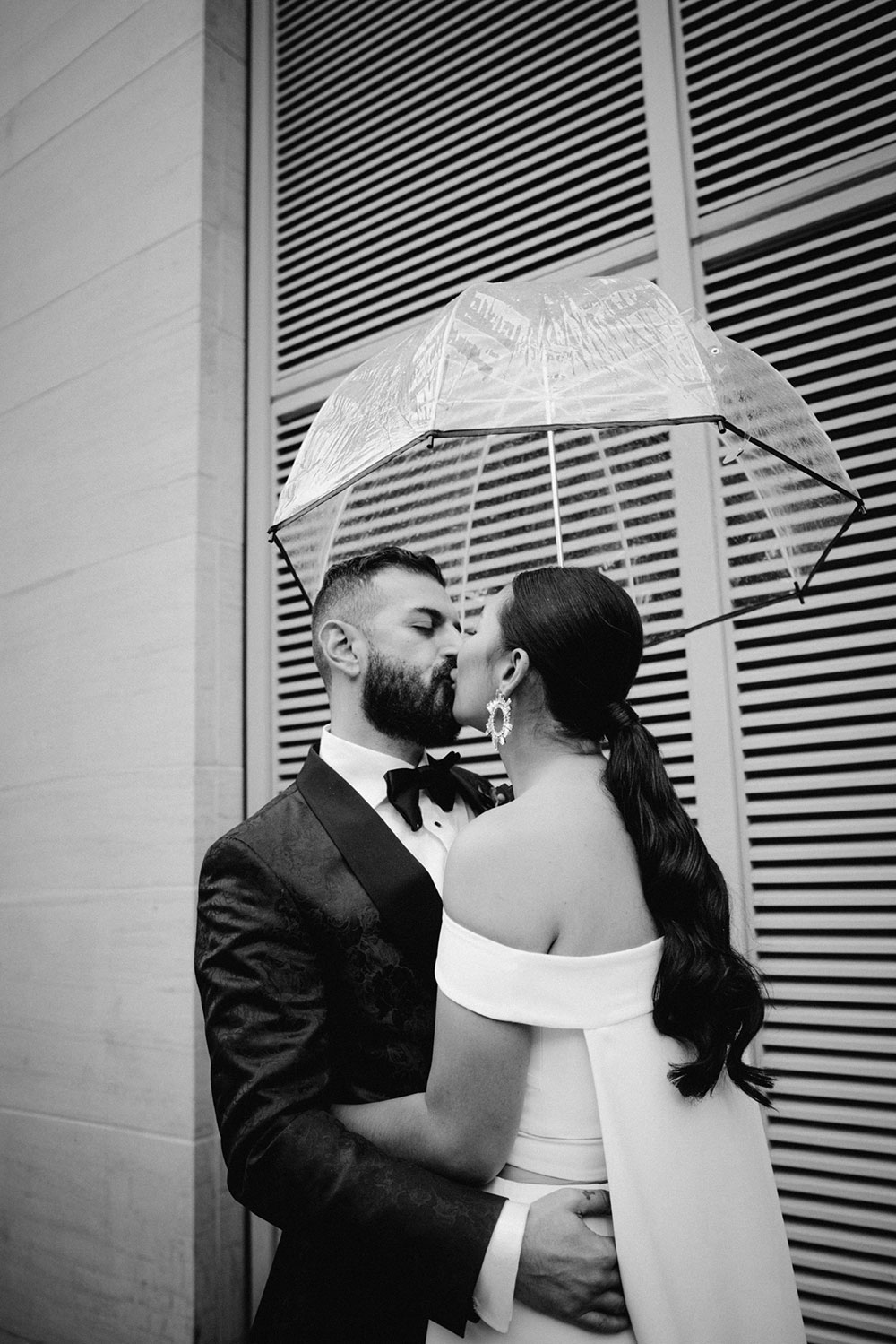 Sassafraz Yorkville Wedding Photography of the bride & groom sharing an umbrella around yorkville