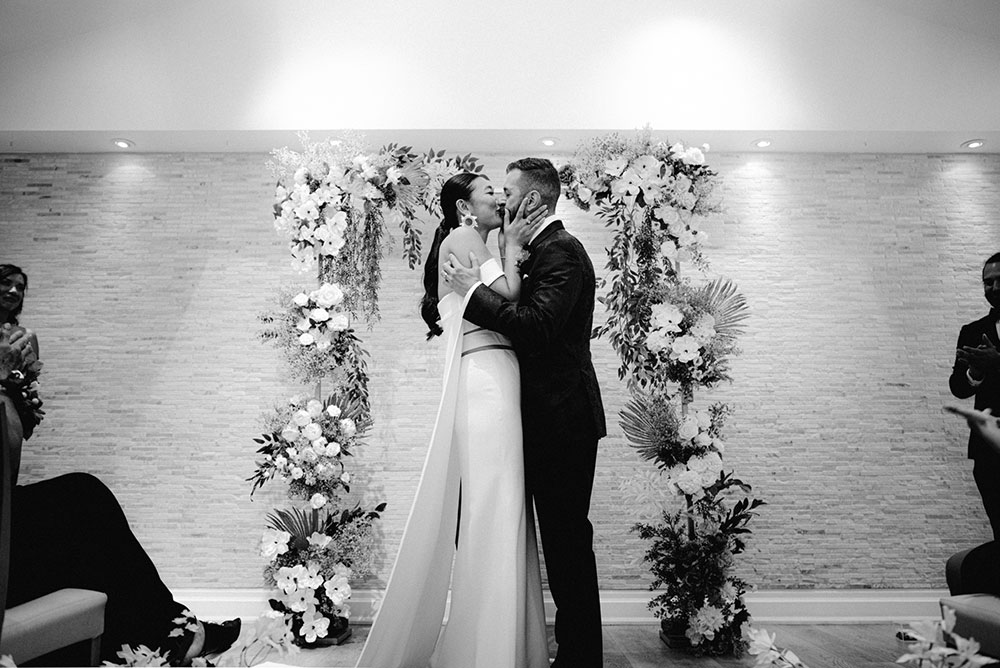 Sassafraz Yorkville Wedding Photography of the bride & groom sharing a kiss at the altar during the wedding ceremony