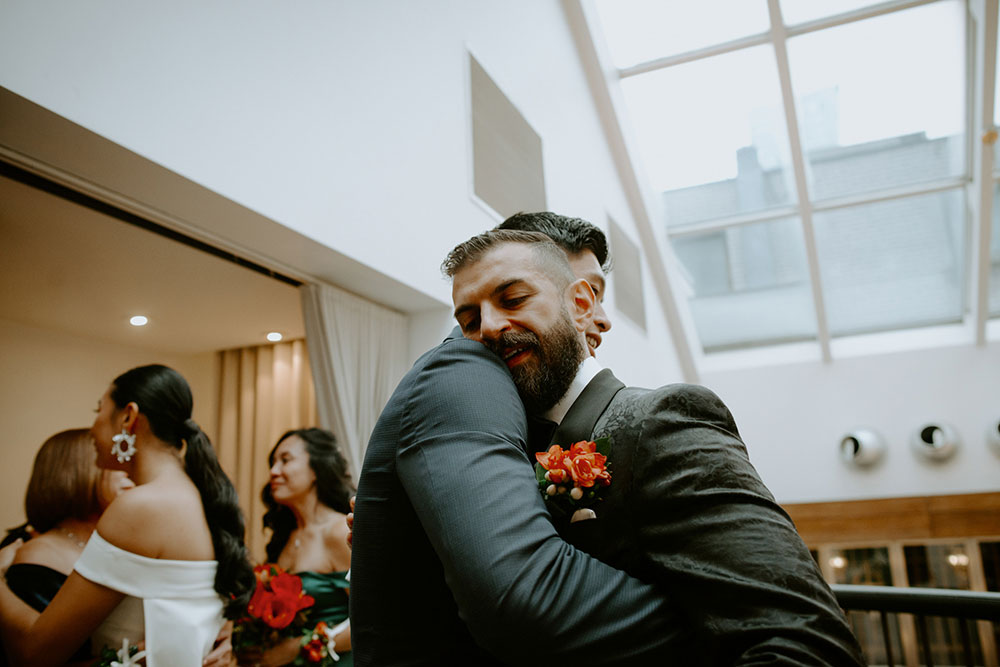 Sassafraz Yorkville Wedding Photography of the groom hugging a guest