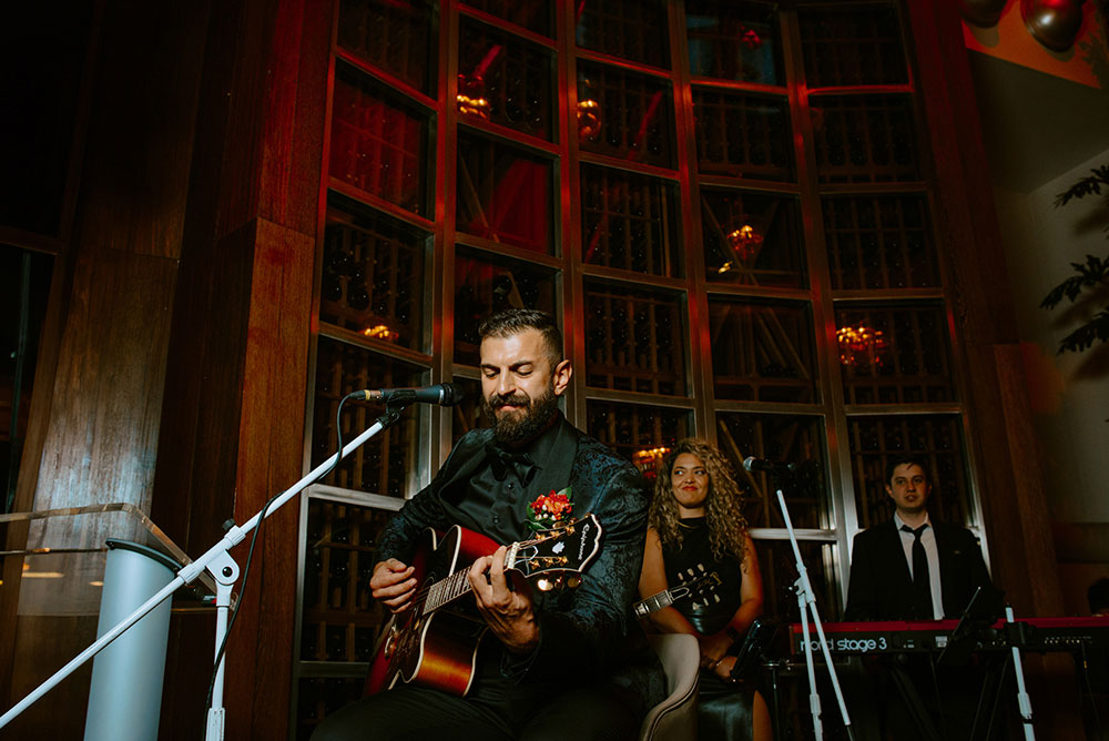 Sassafraz Yorkville Wedding Photography of the groom serenading his bride in front of all the guests during the wedding reception