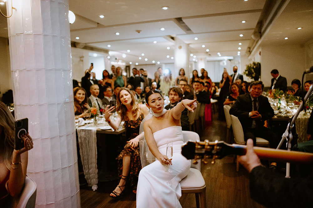 Sassafraz Yorkville Wedding Photography of the groom serenading his bride in front of all the guests during the wedding reception