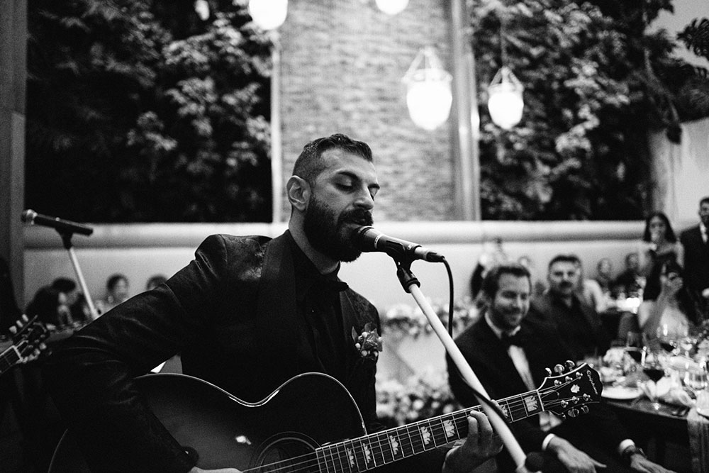 Sassafraz Yorkville Wedding Photography of the groom serenading his bride in front of all the guests during the wedding reception