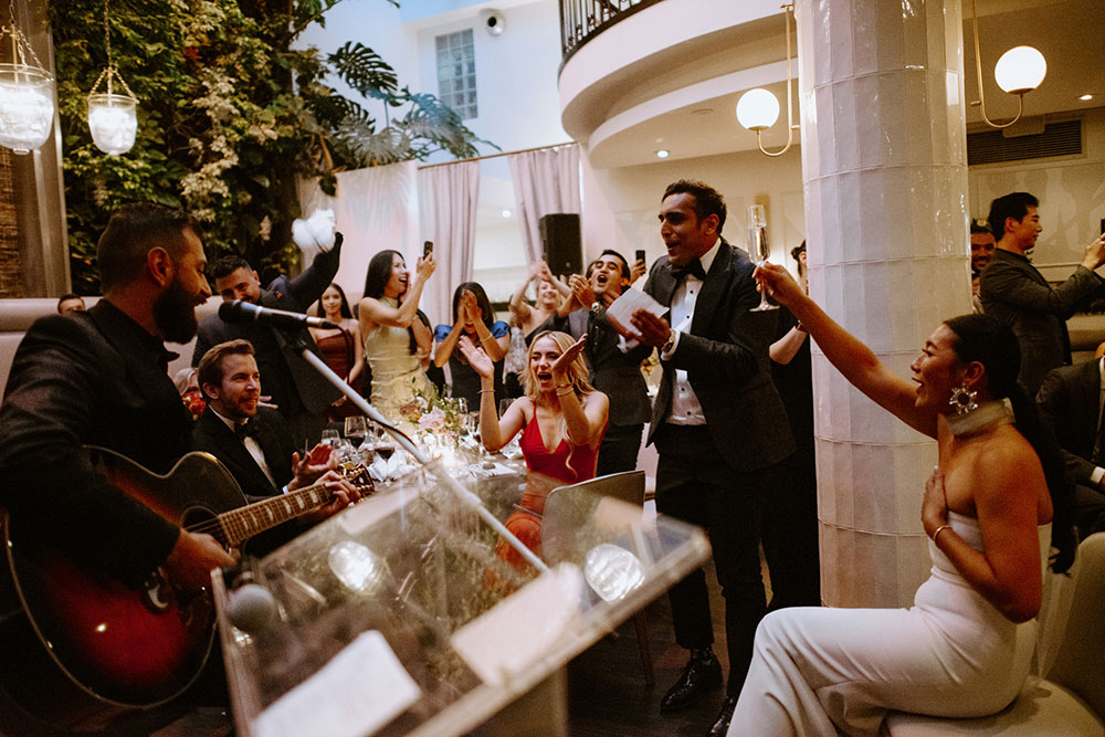 Sassafraz Yorkville Wedding Photography of the groom serenading his bride in front of all the guests during the wedding reception