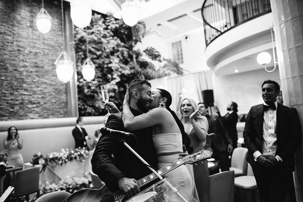 Sassafraz Yorkville Wedding Photography of the groom serenading his bride in front of all the guests during the wedding reception