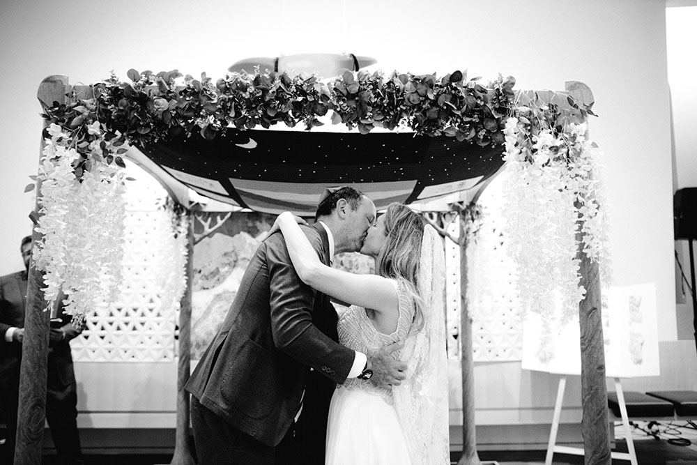 Husband and Wife kiss at their Jewish ceremony on a Toronto Temple