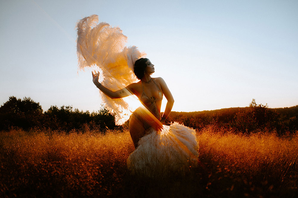 Commercial Photography of Starlotte Satine Toronto Burlesque Dancer in a field wielding large feather fans