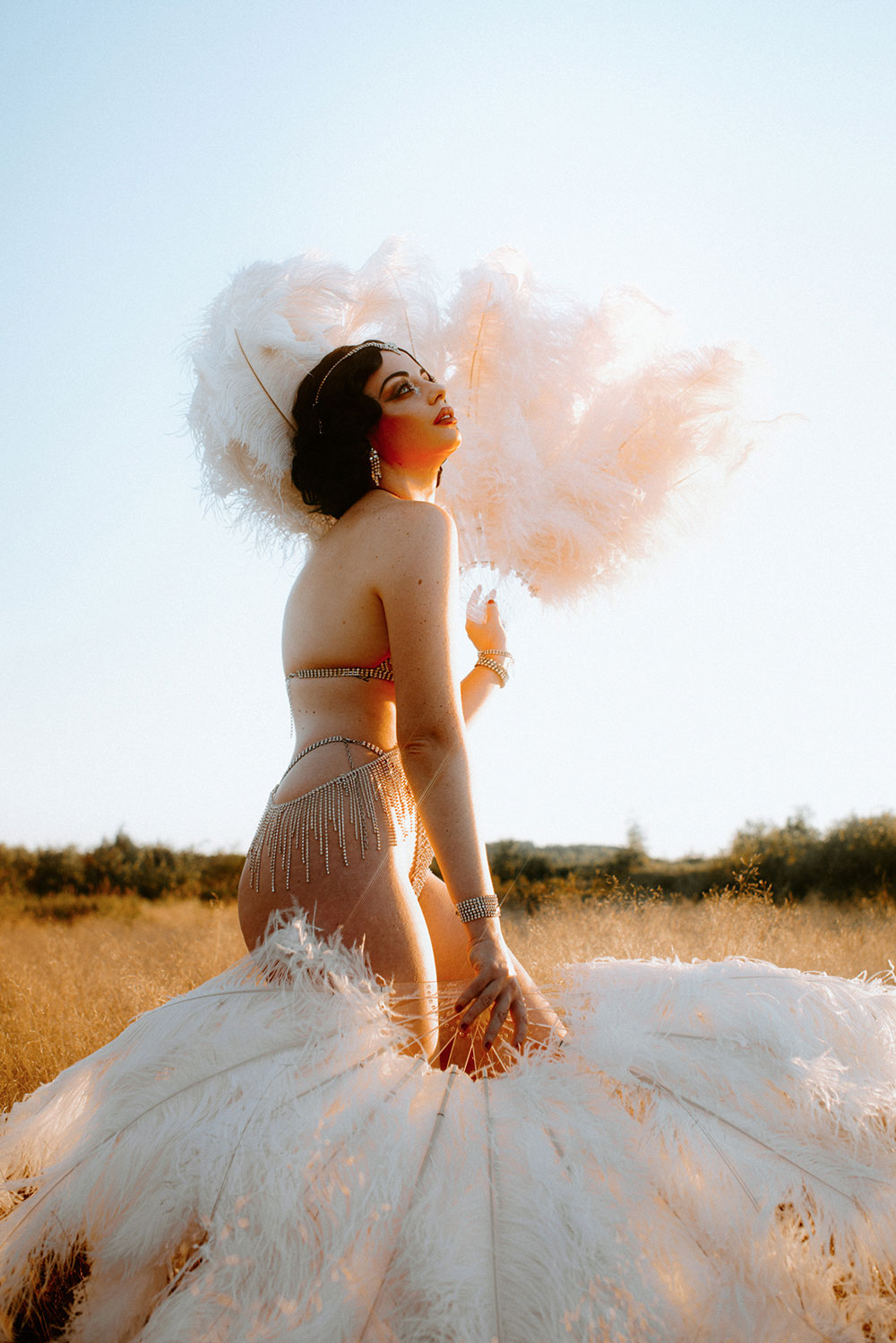 Commercial Photography of Starlotte Satine Toronto Burlesque Dancer in a field wielding large feather fans