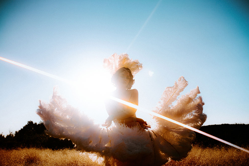 Commercial Photography of Starlotte Satine Toronto Burlesque Dancer in a field wielding large feather fans