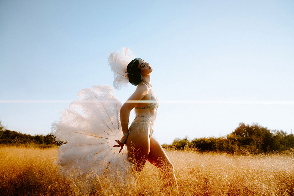 Commercial Photography of Starlotte Satine Toronto Burlesque Dancer in a field wielding large feather fans