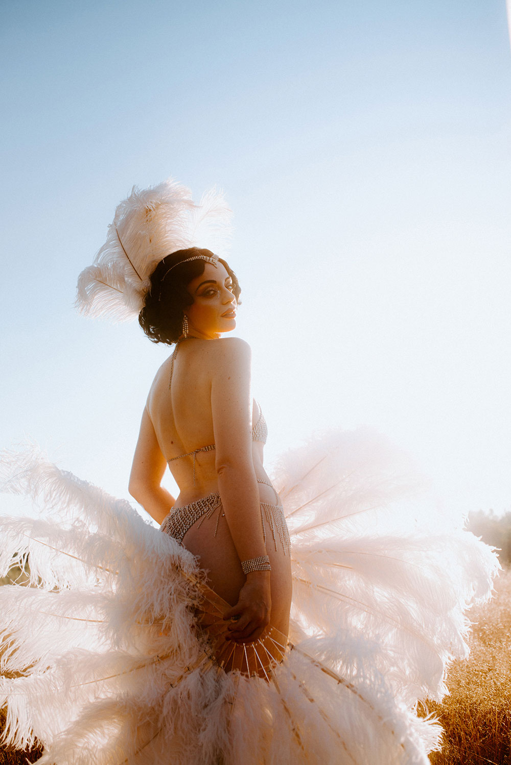 Commercial Photography of Starlotte Satine Toronto Burlesque Dancer in a field wielding large feather fans