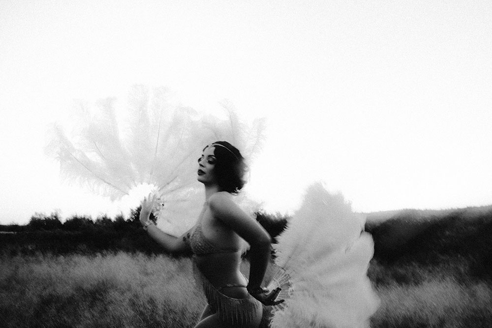 Commercial Photography of Starlotte Satine Toronto Burlesque Dancer in a field wielding large feather fans