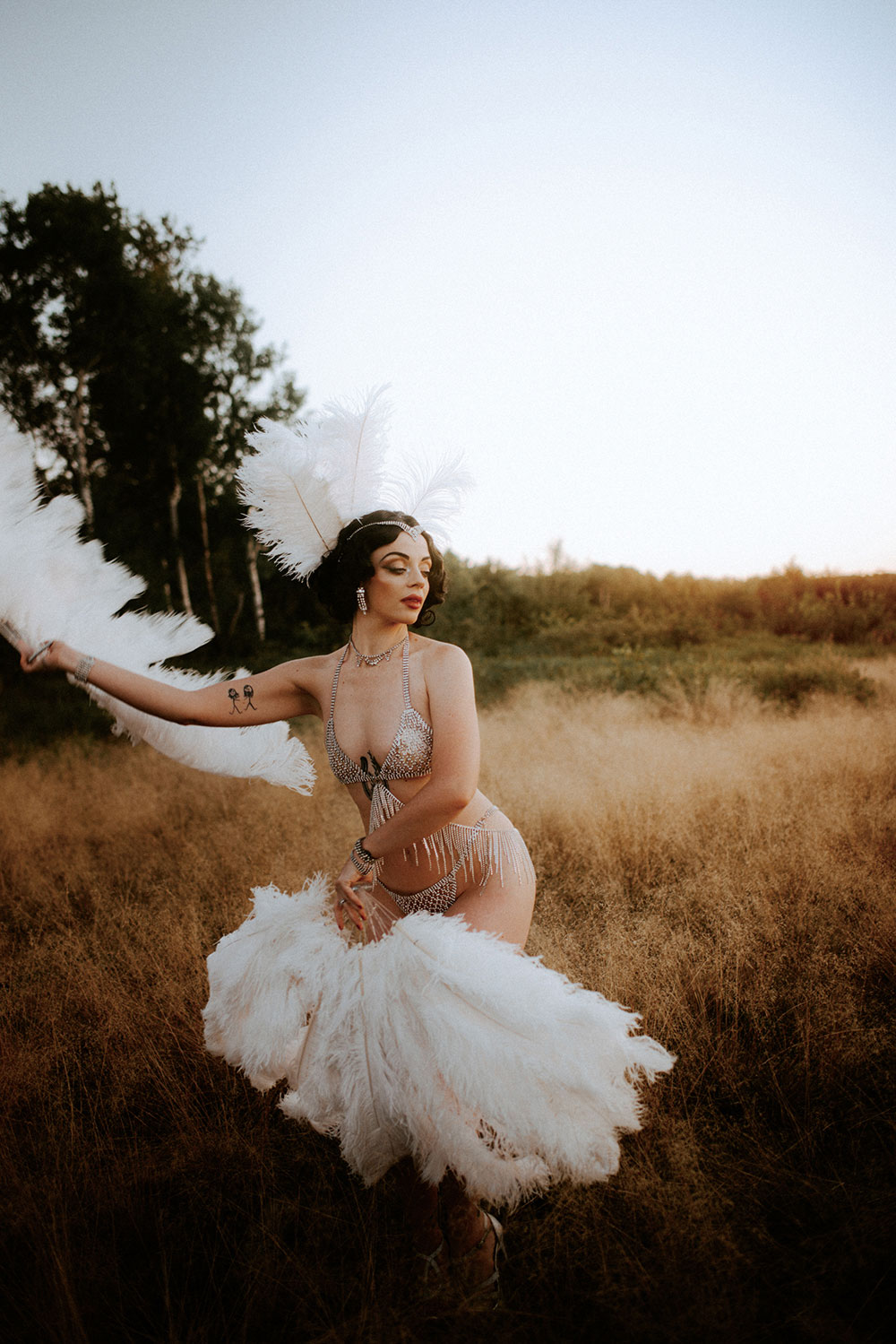 Commercial Photography of Starlotte Satine Toronto Burlesque Dancer in a field wielding large feather fans