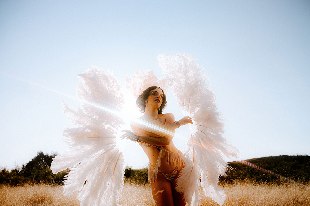 Commercial Photography of Starlotte Satine Toronto Burlesque Dancer in a field wielding large feather fans