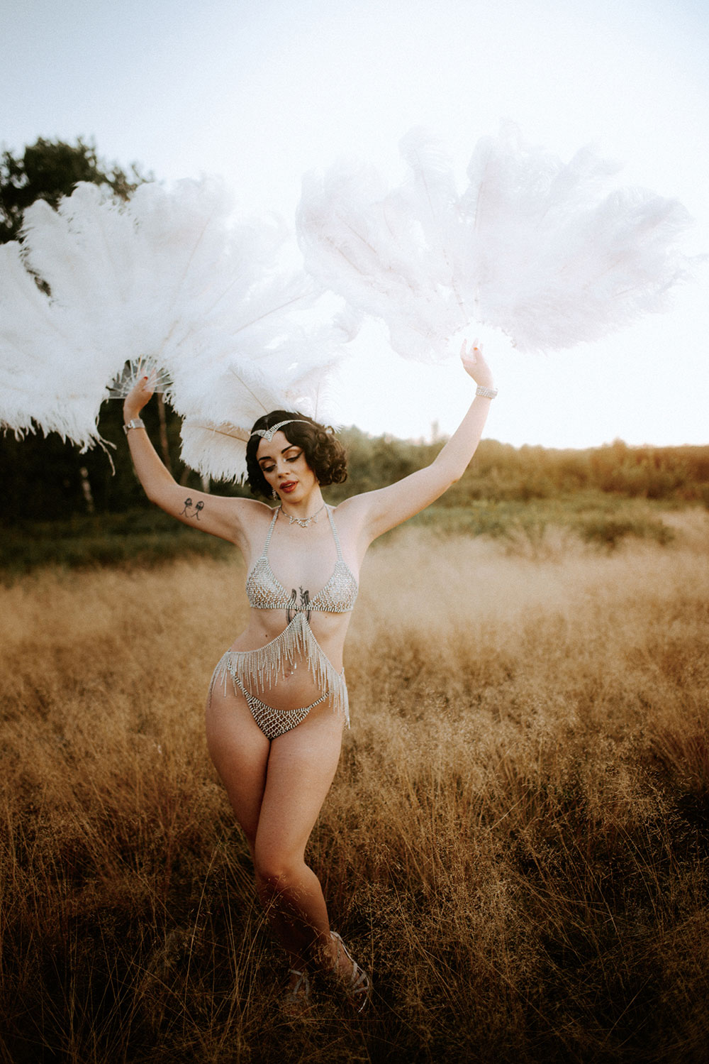 Commercial Photography of Starlotte Satine Toronto Burlesque Dancer in a field wielding large feather fans