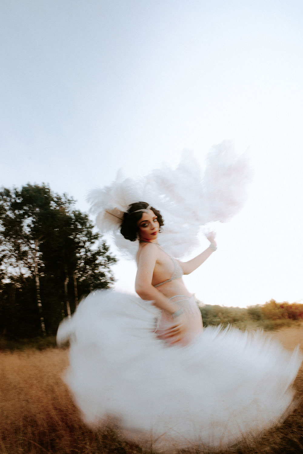 Commercial Photography of Starlotte Satine Toronto Burlesque Dancer in a field wielding large feather fans