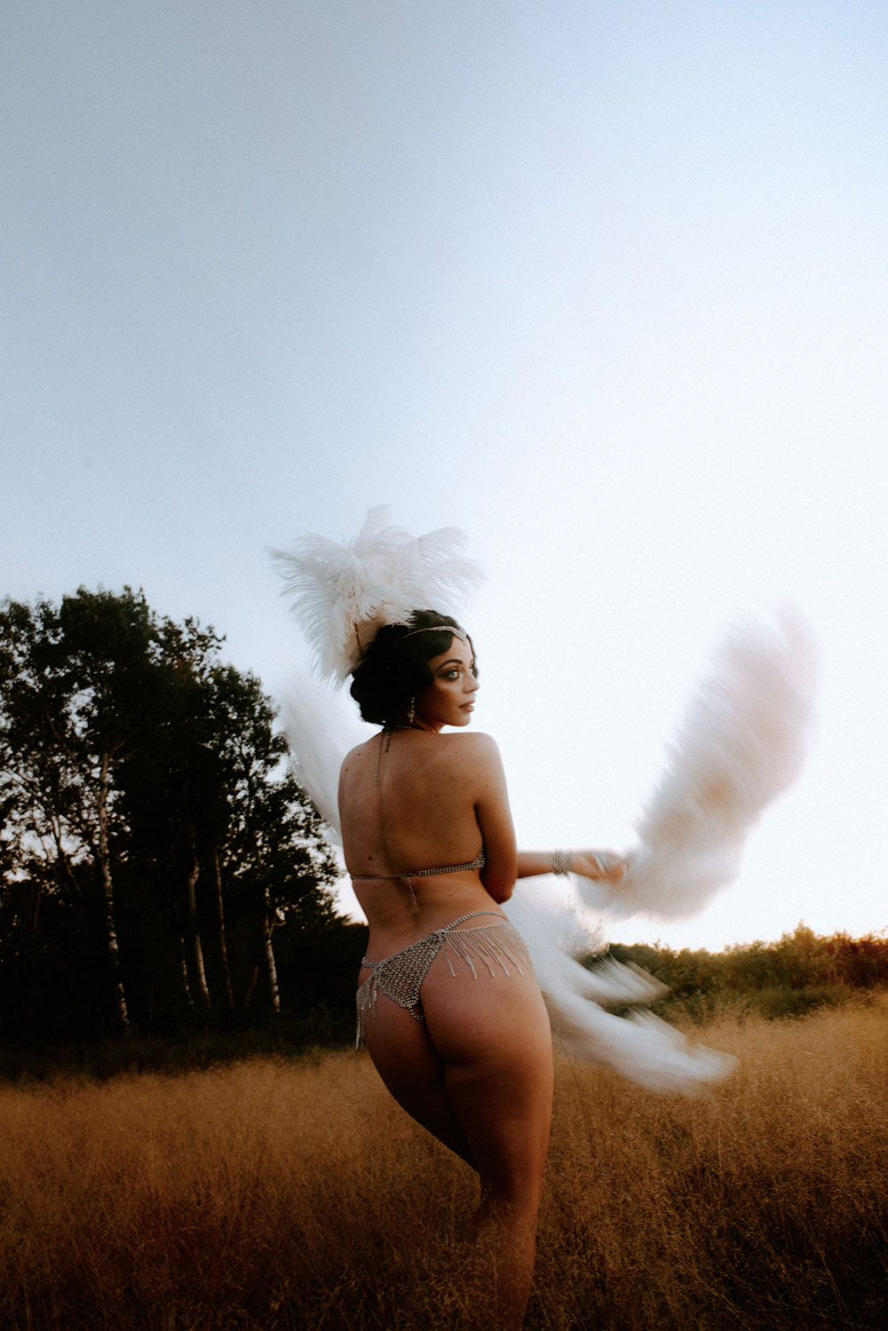 Commercial Photography of Starlotte Satine Toronto Burlesque Dancer in a field wielding large feather fans