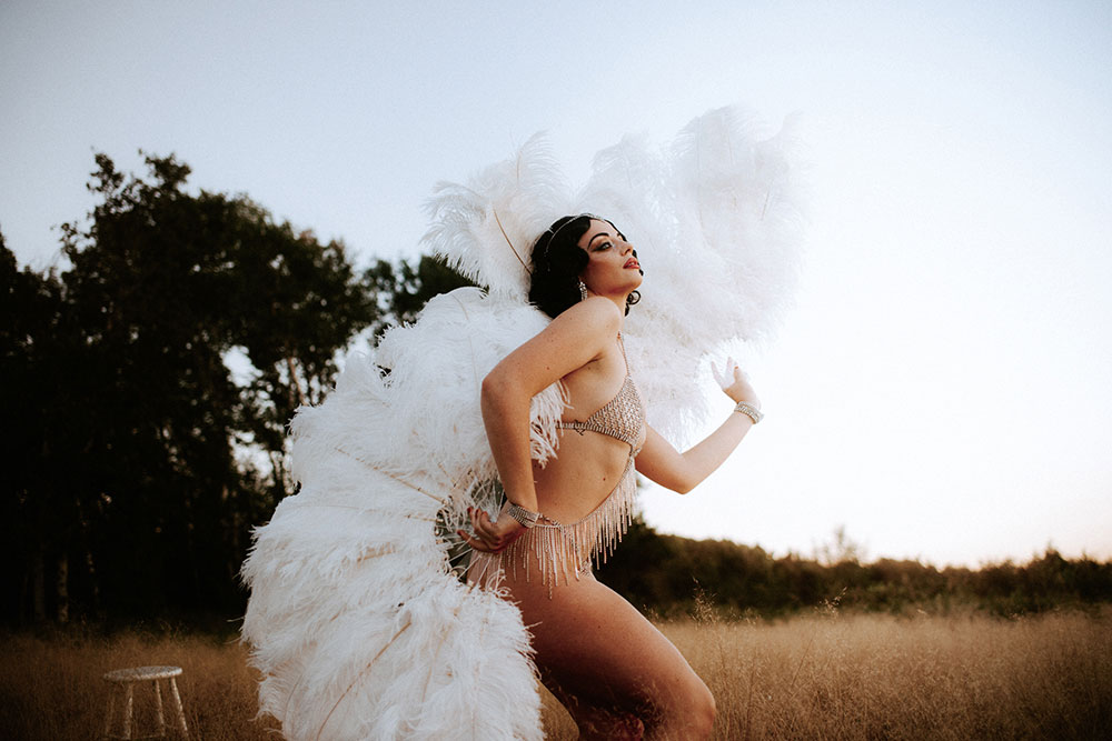 Commercial Photography of Starlotte Satine Toronto Burlesque Dancer in a field wielding large feather fans