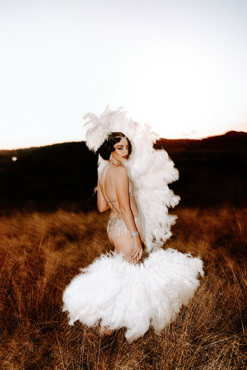 Commercial Photography of Starlotte Satine Toronto Burlesque Dancer in a field wielding large feather fans