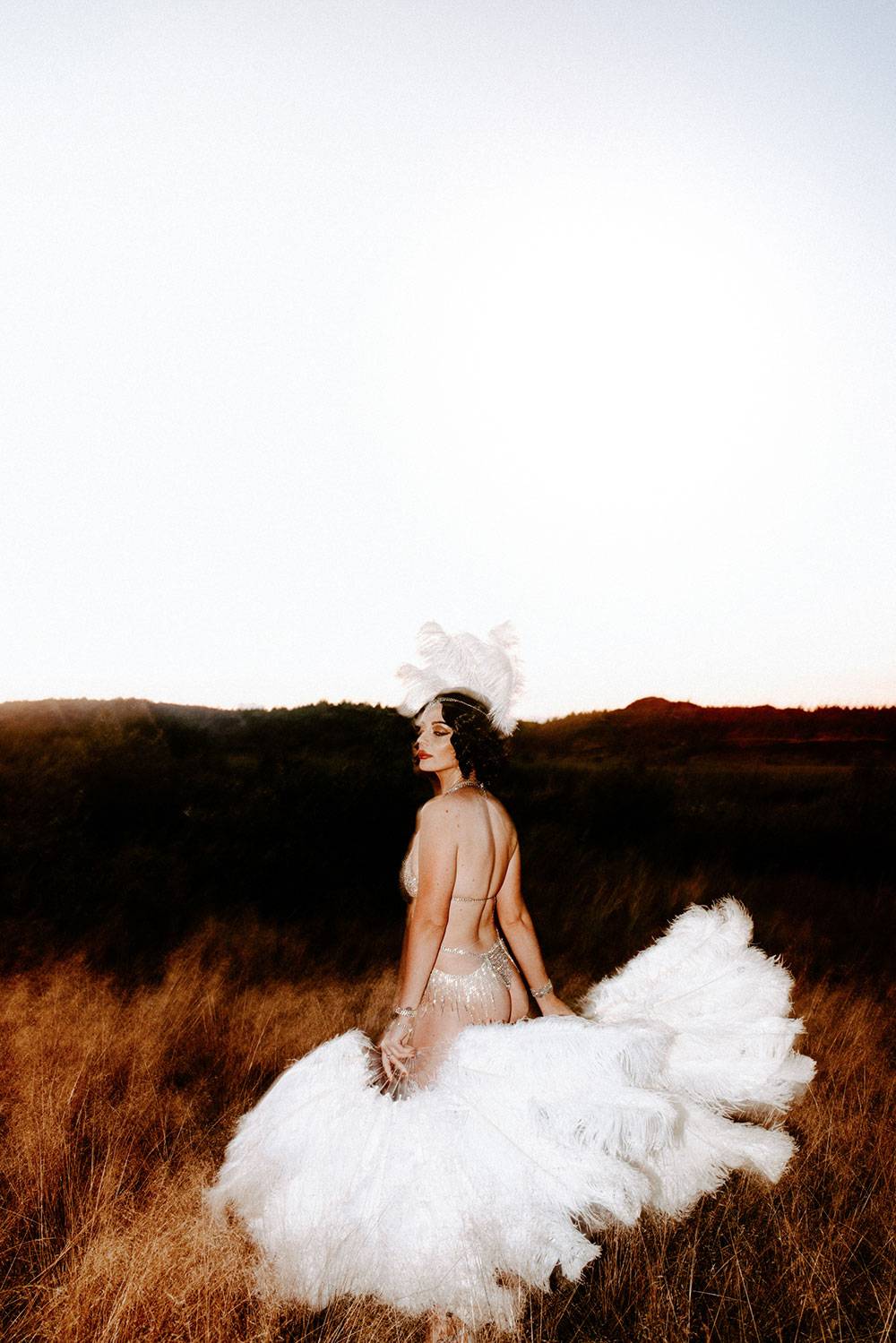 Commercial Photography of Starlotte Satine Toronto Burlesque Dancer in a field wielding large feather fans