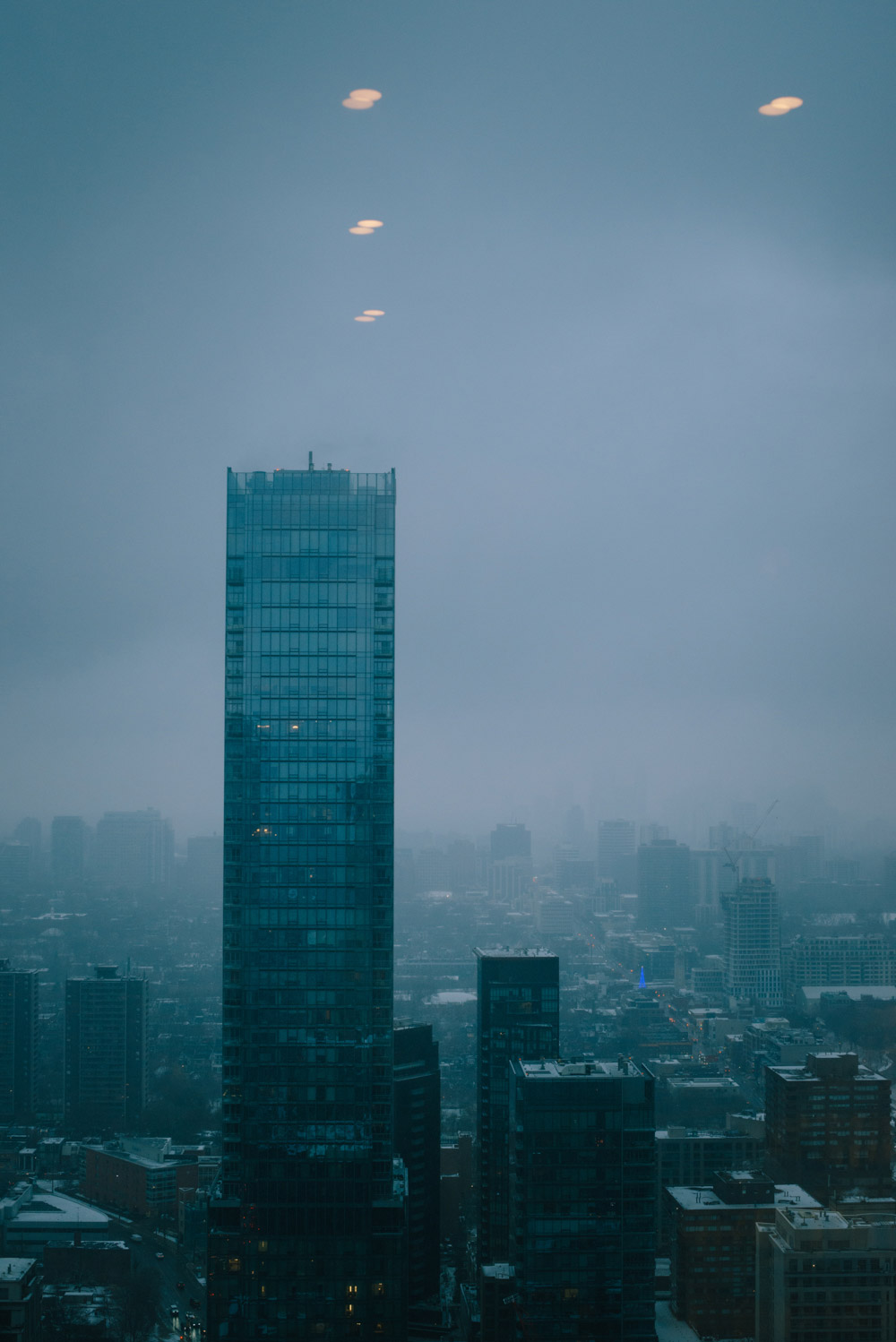 View of tall tower on a wintery foggy day in Toronto from the 51st floor of the manlike centre at the Antonio Park retaurant in Yorkville