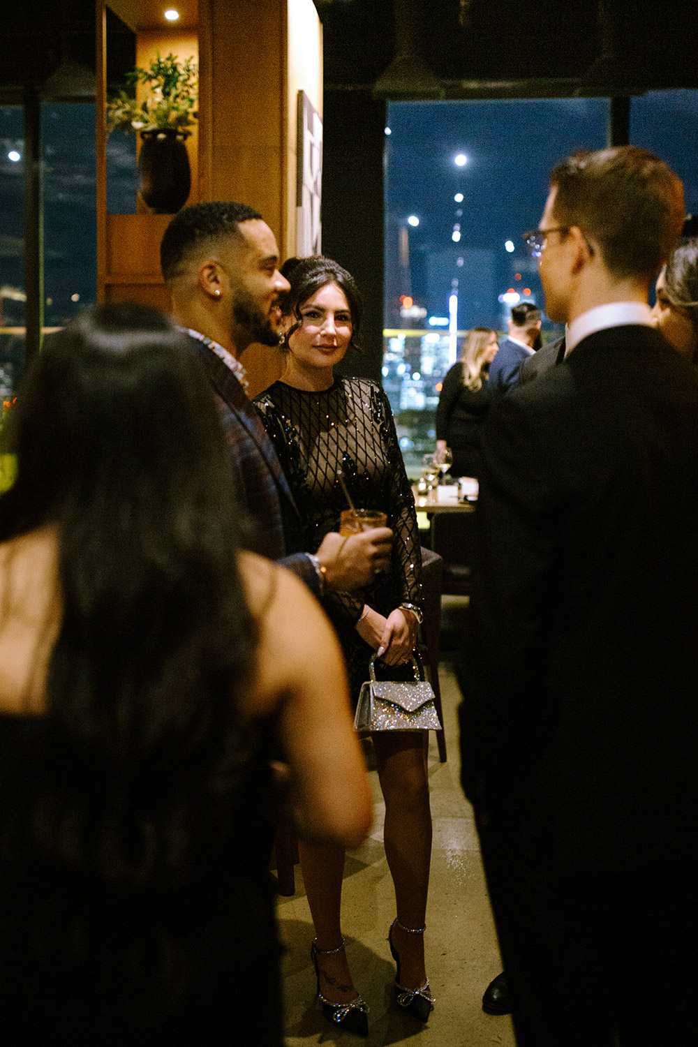 woman looks to camera while enjoying cocktail hour at an Antonio Park wedding