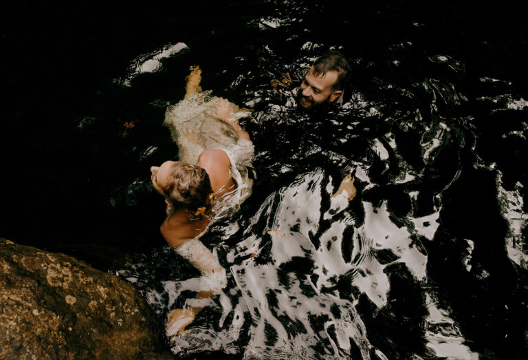 Belize Wedding Photography of a wedding couple who just jumped into a jungle waterfall & swam together laughing.